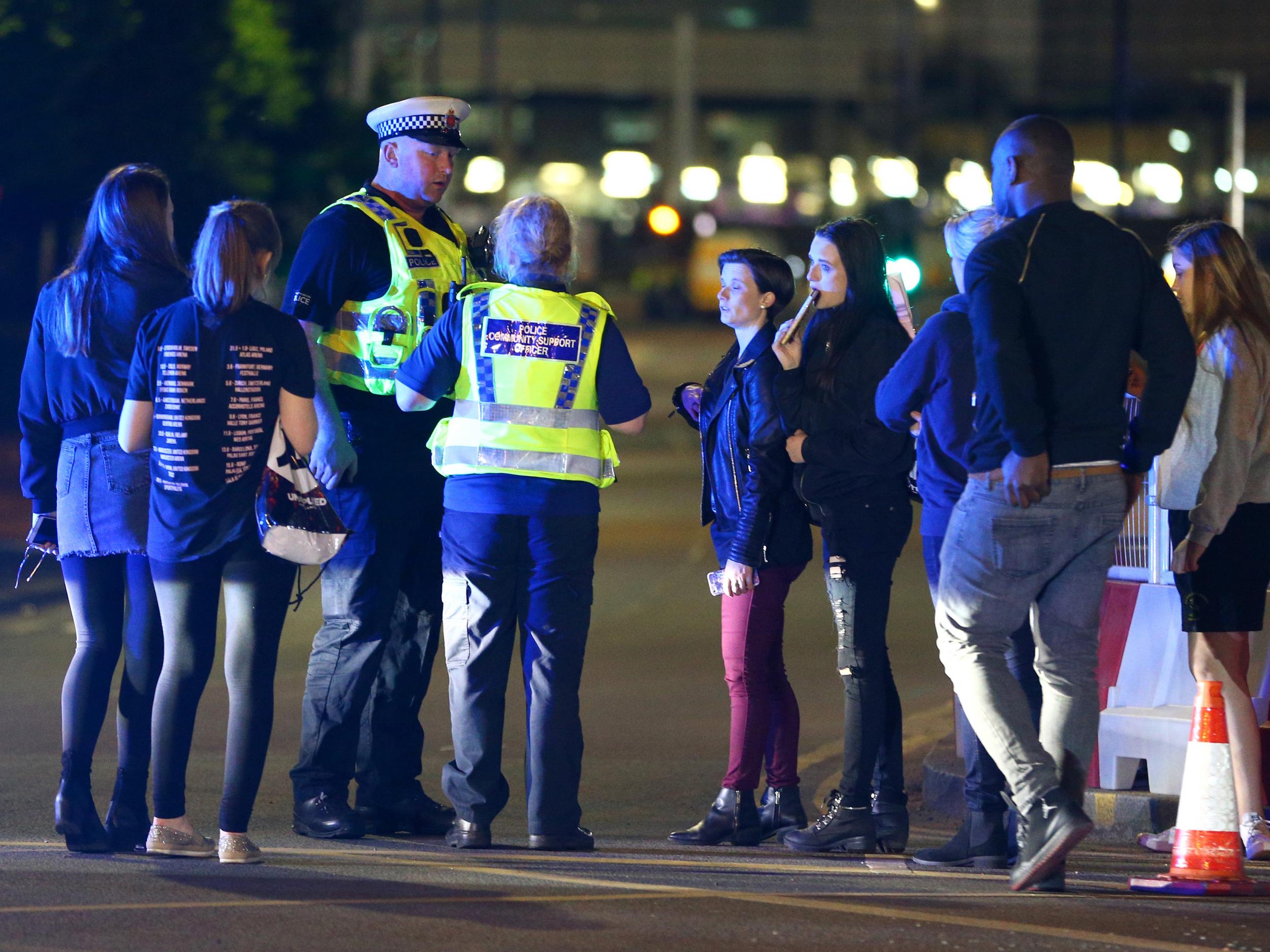 Survivors with police outside the Manchester Arena, where a suicide bomber killed and injured gig-goers on Monday night