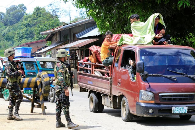 Government troops check a vehicle evacuating residents from their hometown of Marawi city in the Philippines as it drives past a military checkpoint in Pantar town, Lanao Del Norte