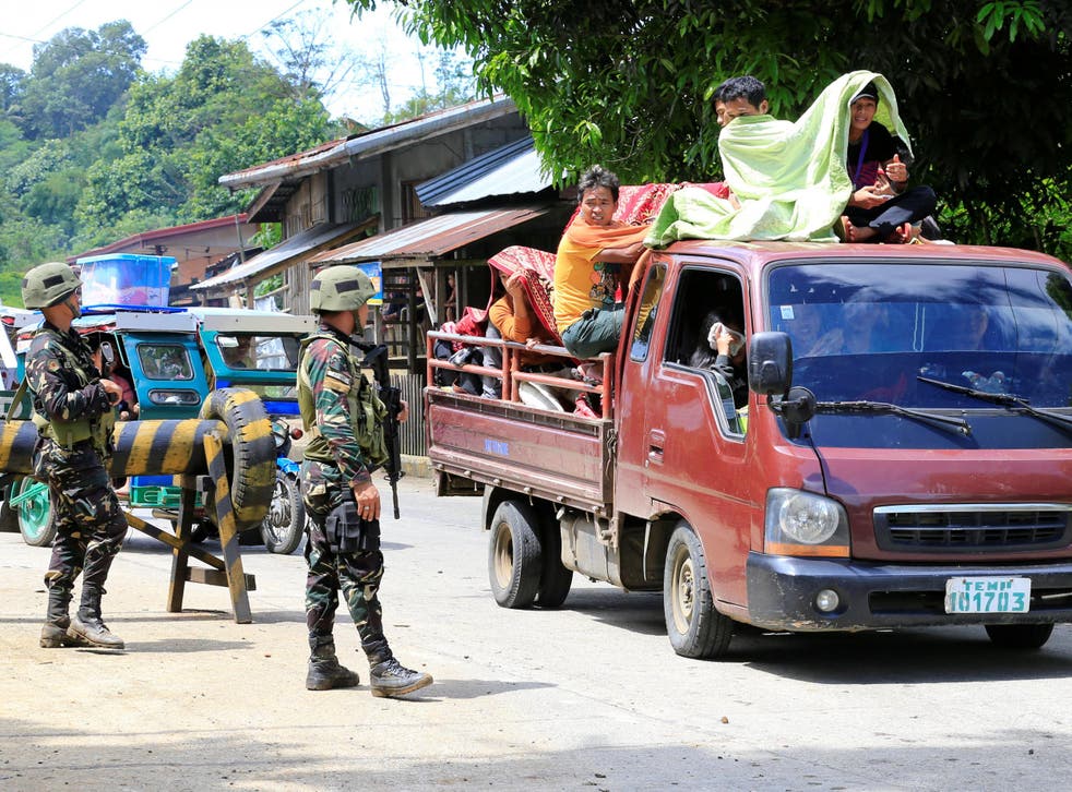 Government troops check a vehicle evacuating residents from their hometown of Marawi city in the Philippines as it drives past a military checkpoint in Pantar town, Lanao Del Norte