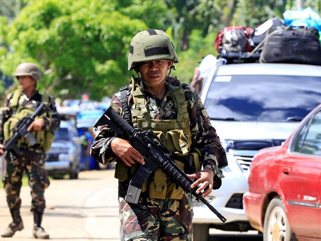 Government troops stand on guard during a checkpoint along a main highway in Pantar town, Lanao del Norte, after residents started to evacuate their hometown of Marawi city, southern Philippines May 24, 2017.
