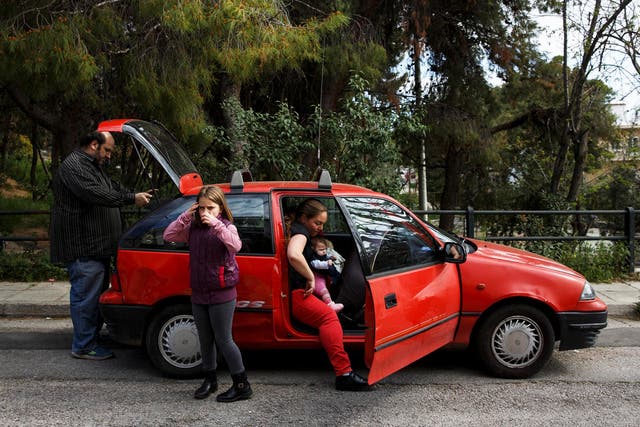 The Argyros family get into their car, which was donated, after receiving goods from Theofilos, an NGO for big families in Athens, Greece