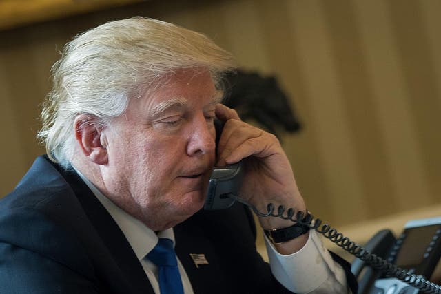 President Donald Trump speaks on the phone with Russian President Vladimir Putin in the Oval Office of the White House
