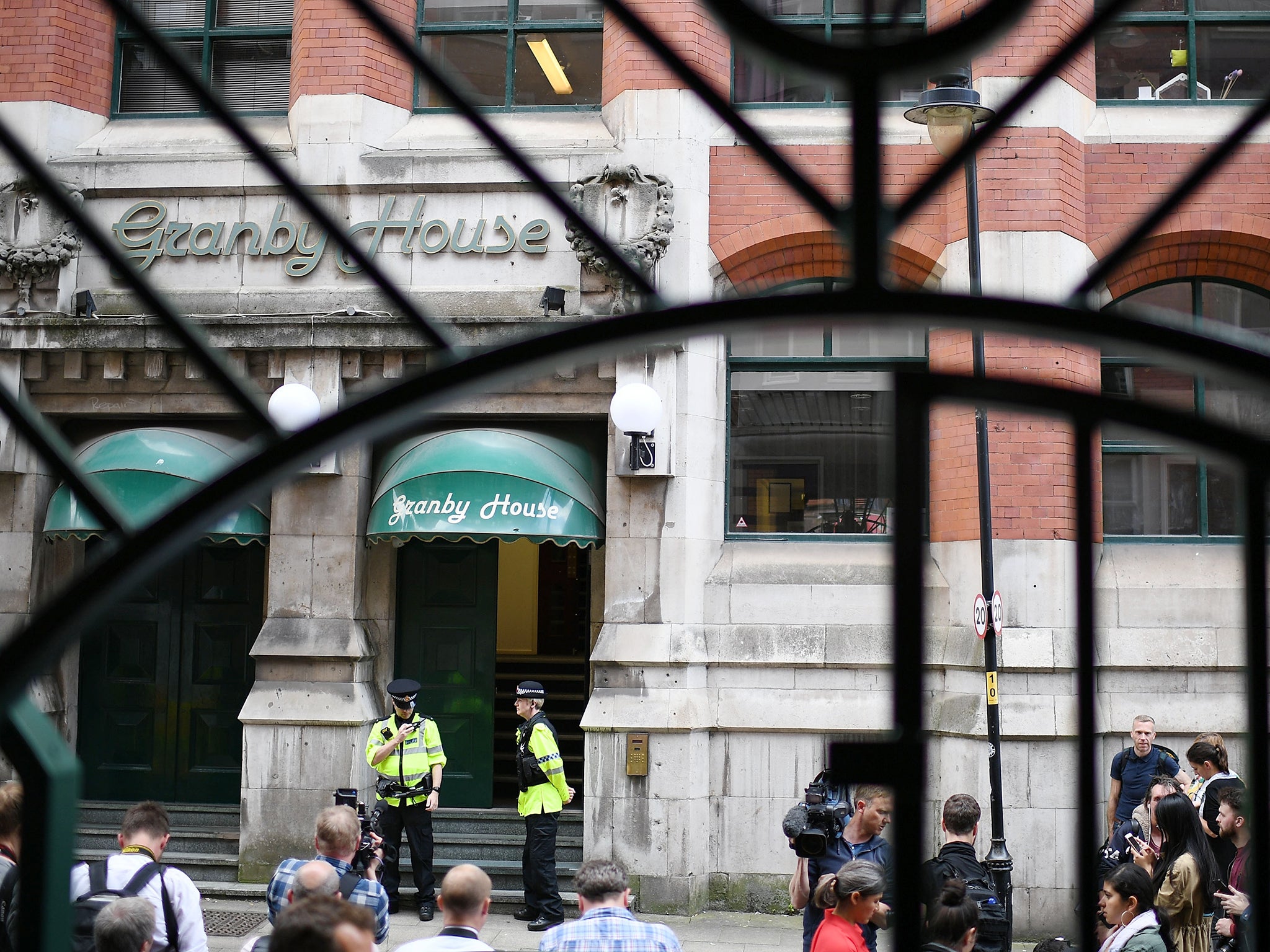 Police guard the entrance to Granby House in the city centre following an armed raid, in Manchester, England