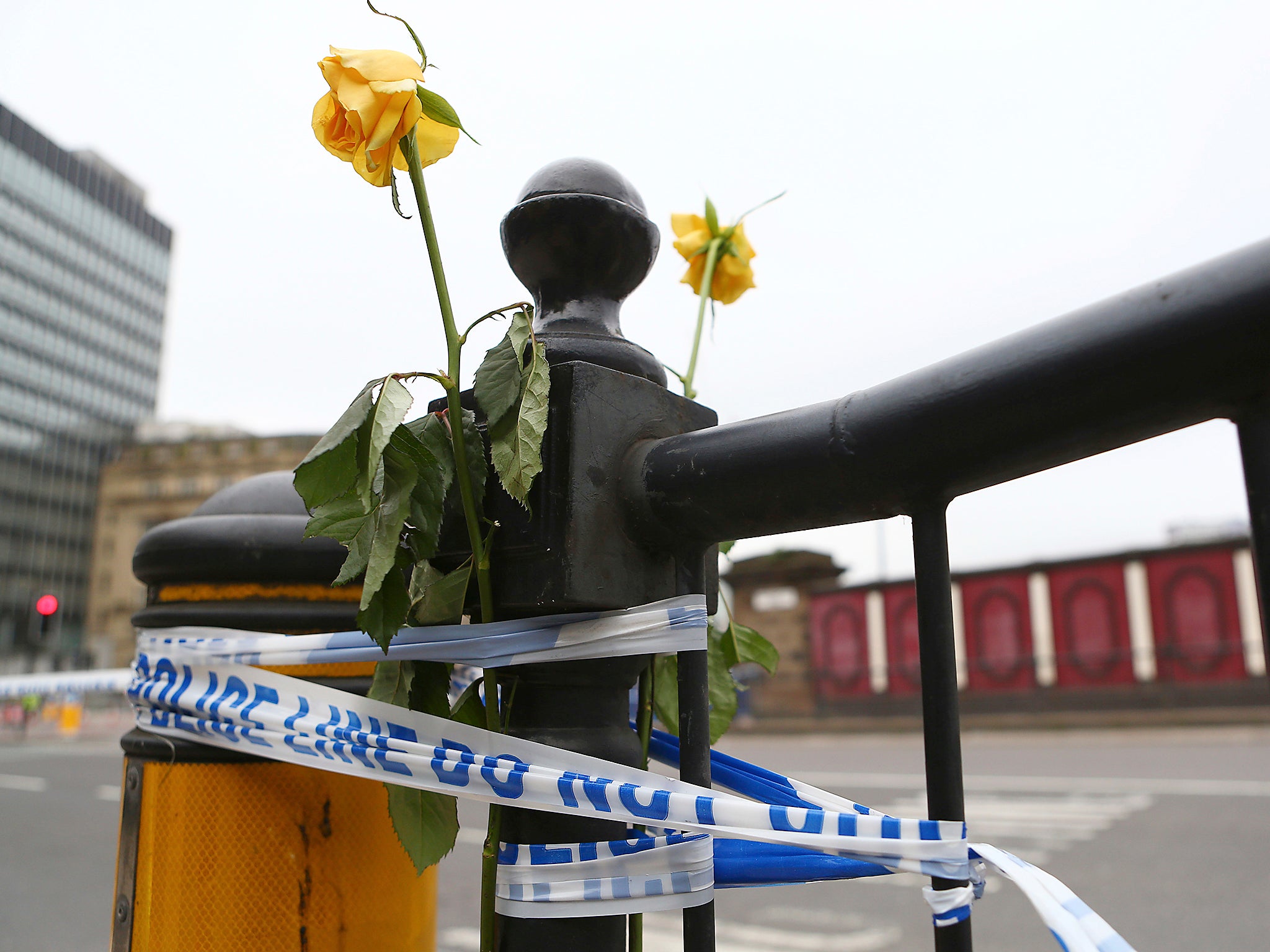 Flowers are attached to a railing close to Victoria Railway Station in Manchester