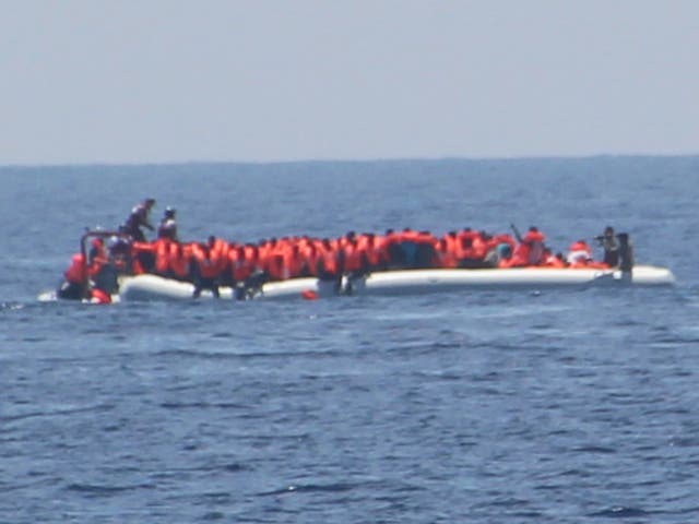 The crew of Jugend Rettet's Iuventa rescue ship photographed what appeared to be a Libyan coastguard officer pointing a weapon at refugees (far right)