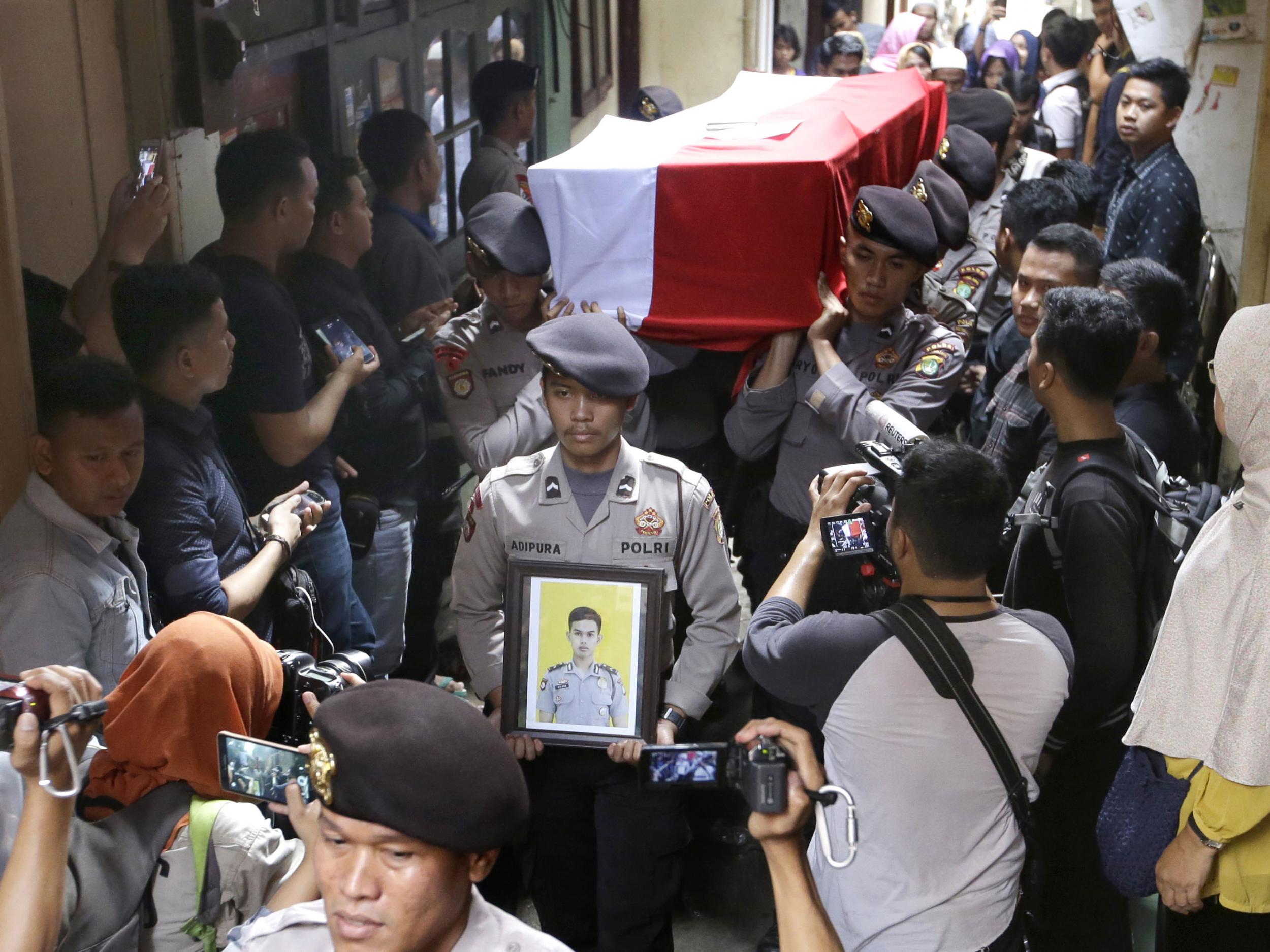 Police officers carry the coffin containing the body of their colleague Sergeant Gilang Imam Adinata who was killed in Wednesday's suicide bombings during a funeral procession in Jakarta on 25 May 25 2017