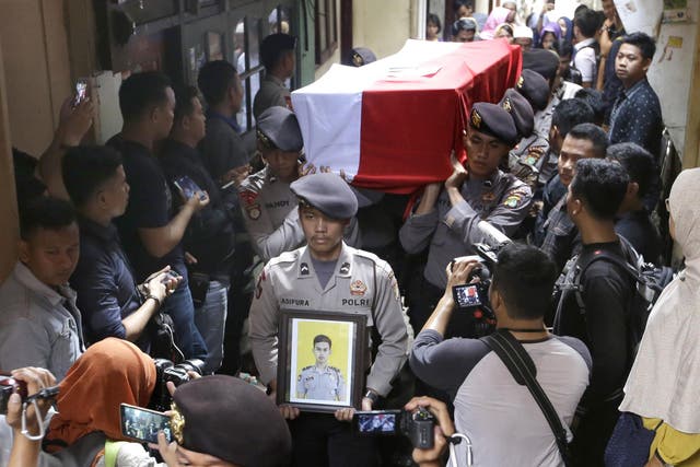Police officers carry the coffin containing the body of their colleague Sergeant Gilang Imam Adinata who was killed in Wednesday's suicide bombings during a funeral procession in Jakarta on 25 May 25 2017