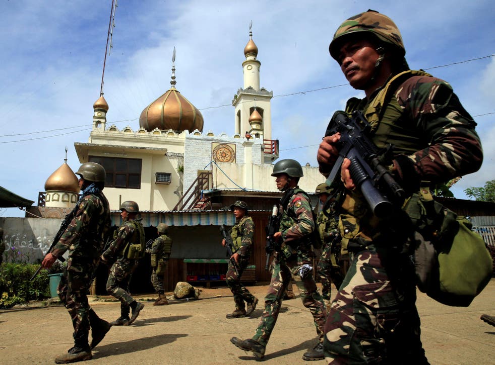 Government troops walk past a mosque before their assault with insurgents from the so-called Maute group, who have taken over large parts of Marawi, southern Philippines