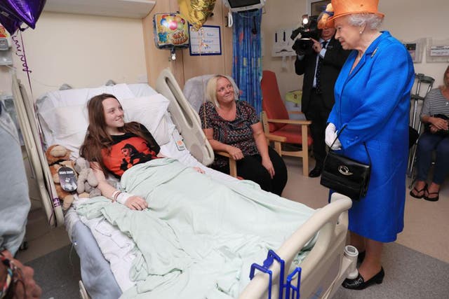 Queen Elizabeth II speaks to Millie Robson, 15, from Co Durham, and her mother, Marie, during a visit to the Royal Manchester Children's Hospital