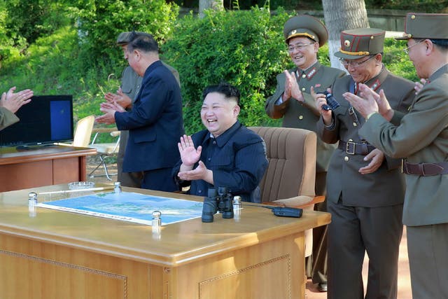 North Korean Leader Kim Jong-un celebrates the latest test-fire of a ground-to-ground medium-to-long range strategic ballistic missile