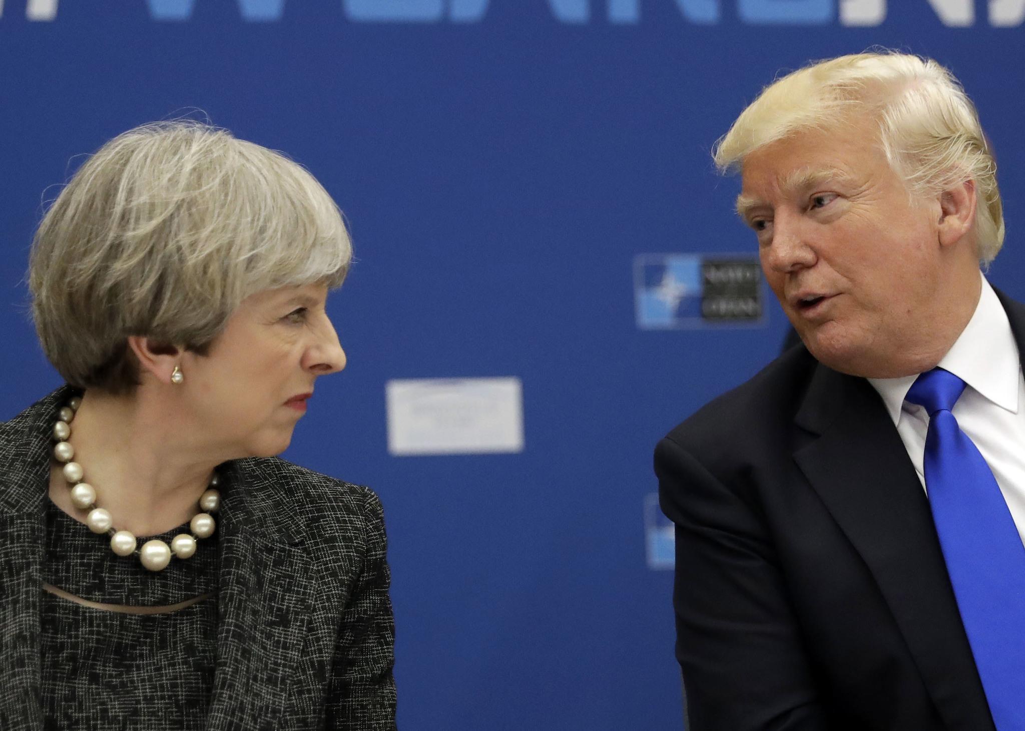 President Donald Trump speaks to British Prime Minister Theresa May during in a working dinner meeting at the NATO headquarters