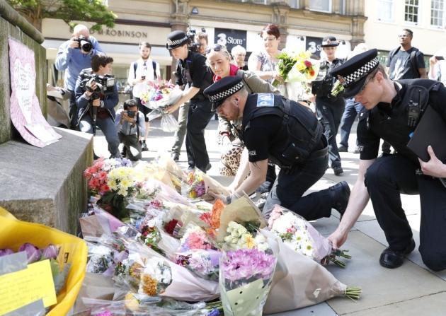 Police officers lay flowers in tribute to the Manchester victims