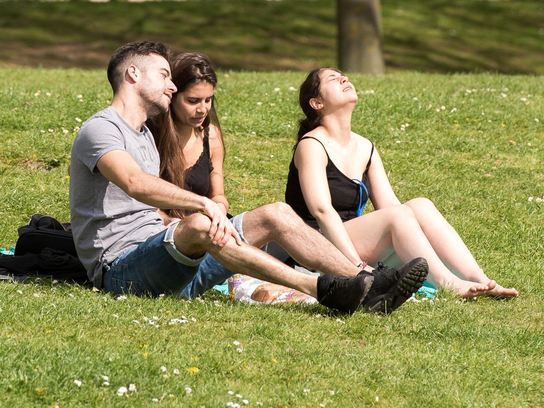 People bask in the sunshine in Castle Park, Bristol