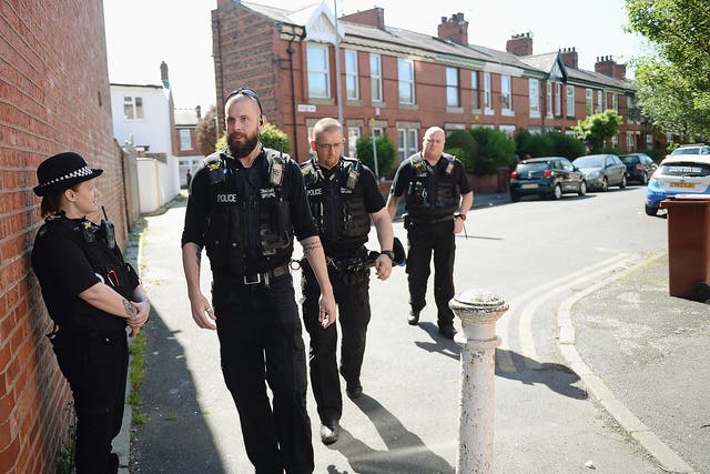Police officers stand on duty on Dorset Avenue in Moss Side, Manchester, following a raid on a residential property as their investigations continue into the May 22 terror attack at the Manchester Arena