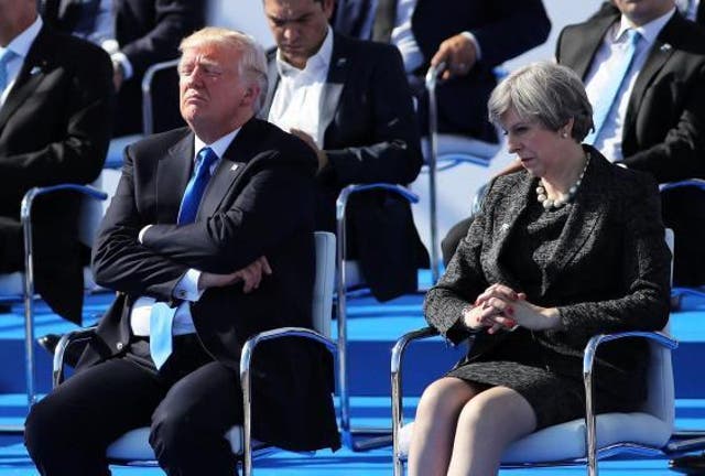Donald Trump sits next to Theresa May at the NATO summit in Brussels