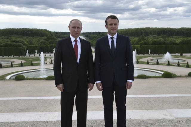 French President Emmanuel Macron, right, and Russian President Vladimir Putin in the gardens of the Chateau de Versailles