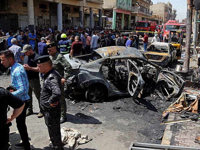Iraqi security forces and civilians inspect the site of the second deadly bomb attack in Baghdad