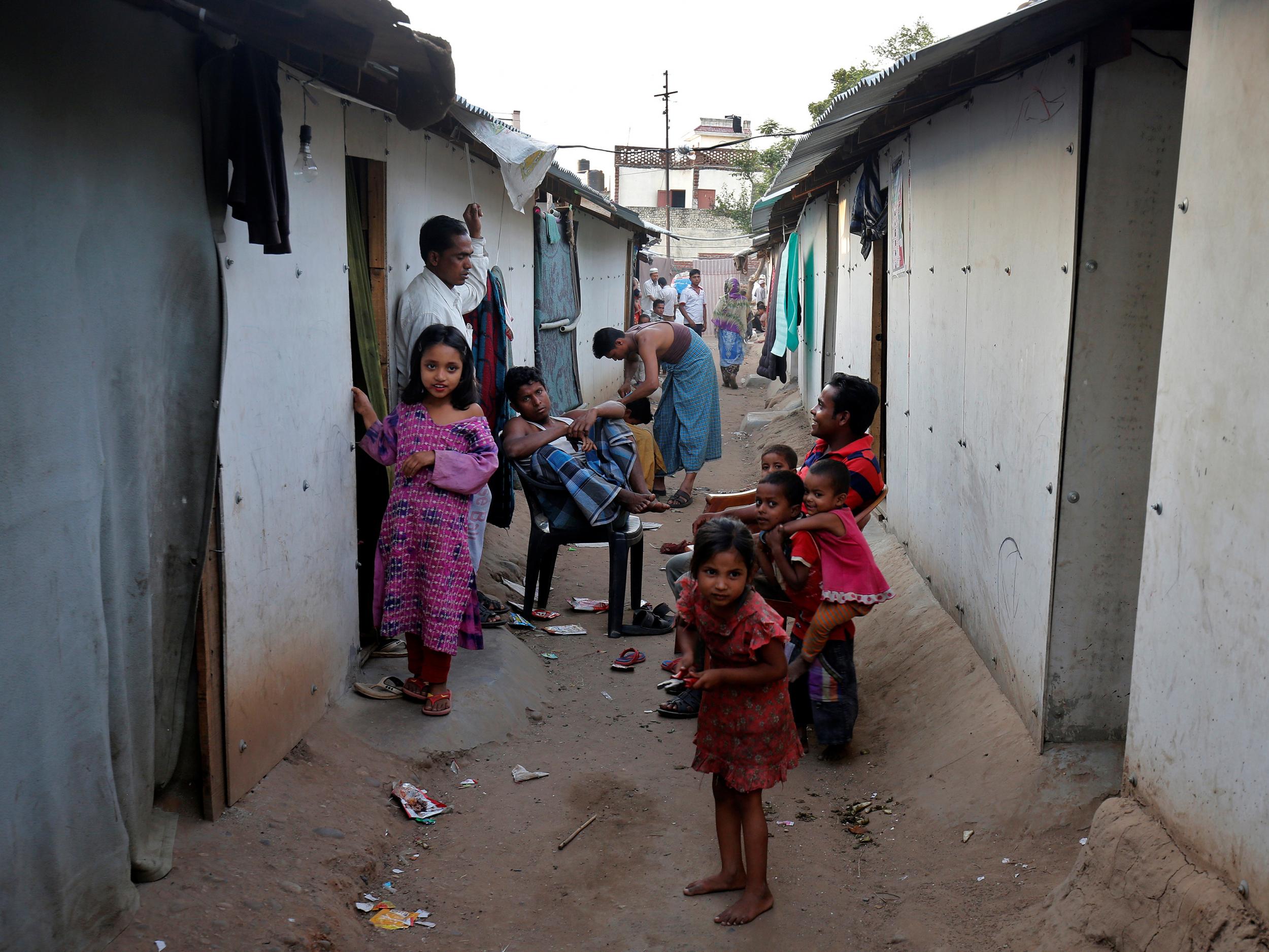 People belonging to Rohingya Muslim community sit outside makeshift houses