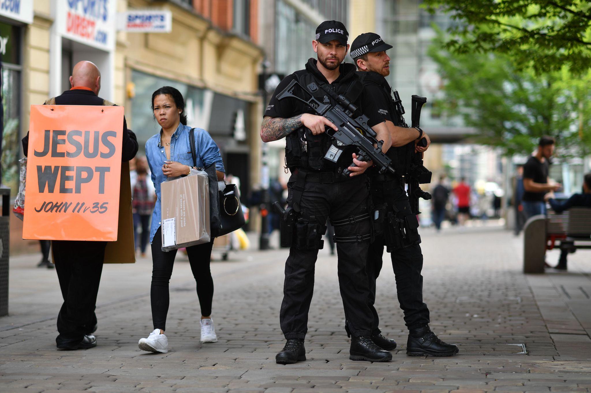 Armed police guard a street in central Manchester following the attacks