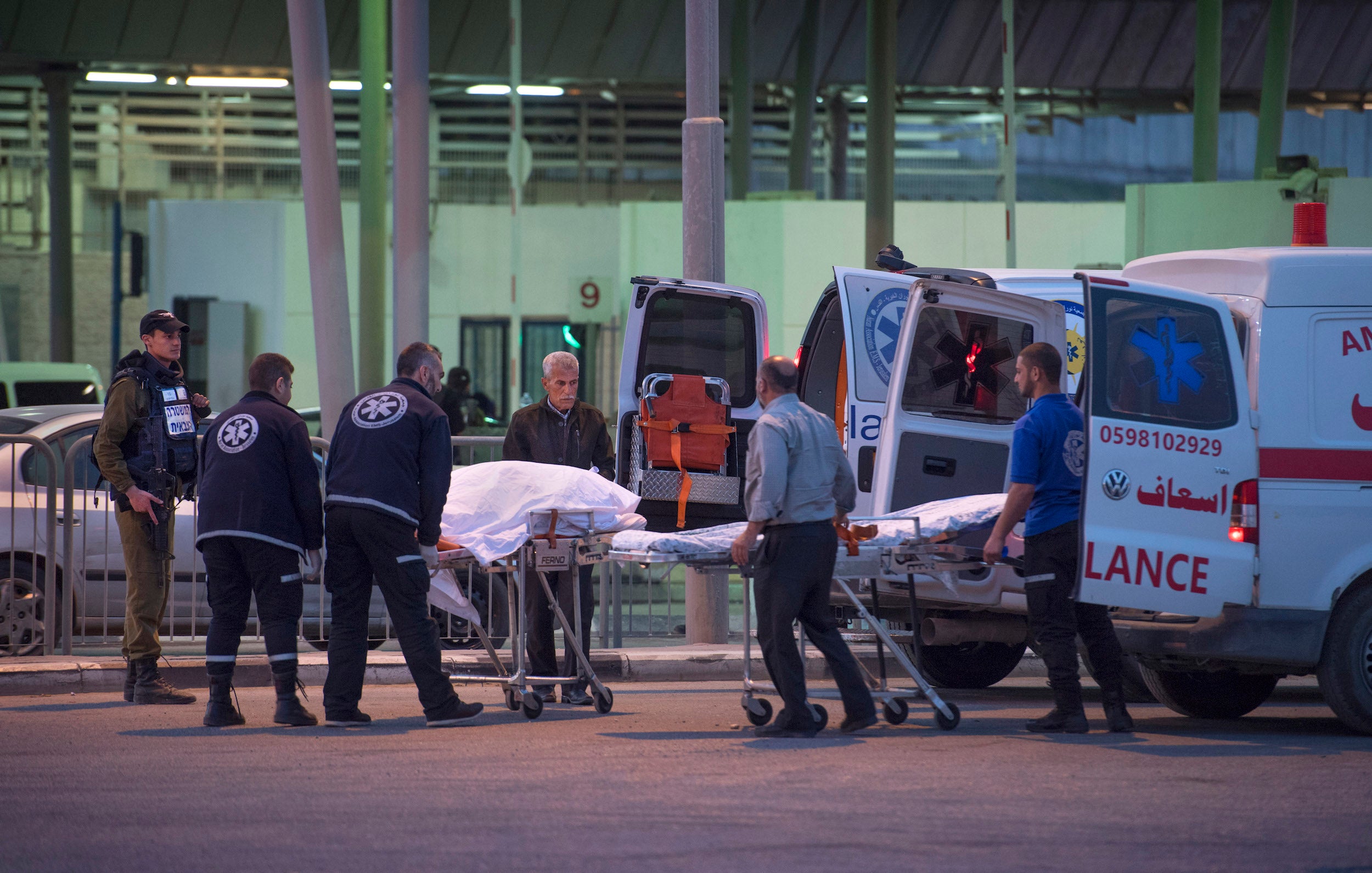 Transfer: Salah’s body is moved from an Israeli ambulance to a Palestinian one at the Qalandia checkpoint as her husband watches