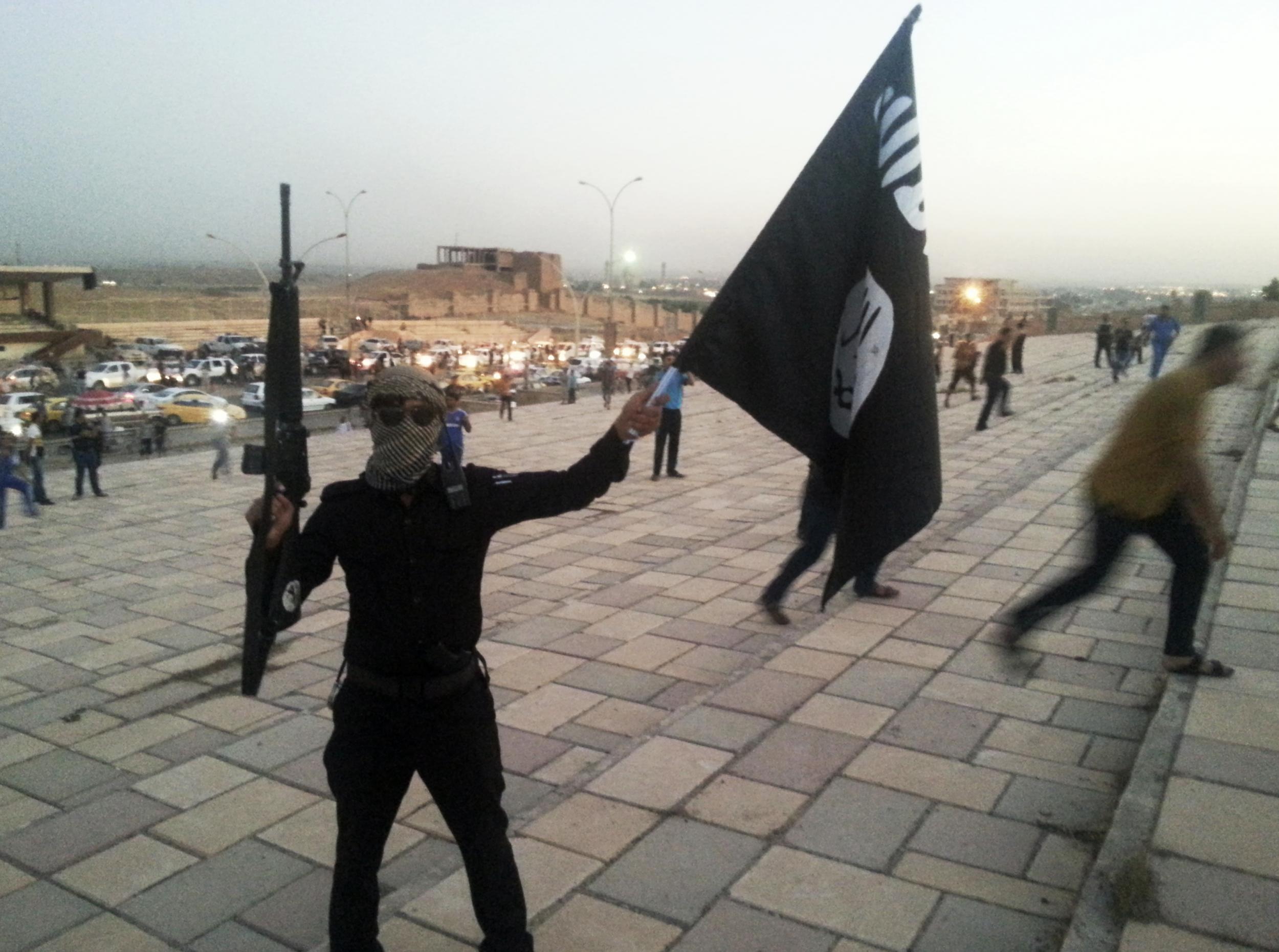 An Isis fighter holds up the group's flag after seizing the Iraqi city of Mosul on 23 June 2014. A seven-month long US-led coalition effort to free the city has almost succeeded in its goal