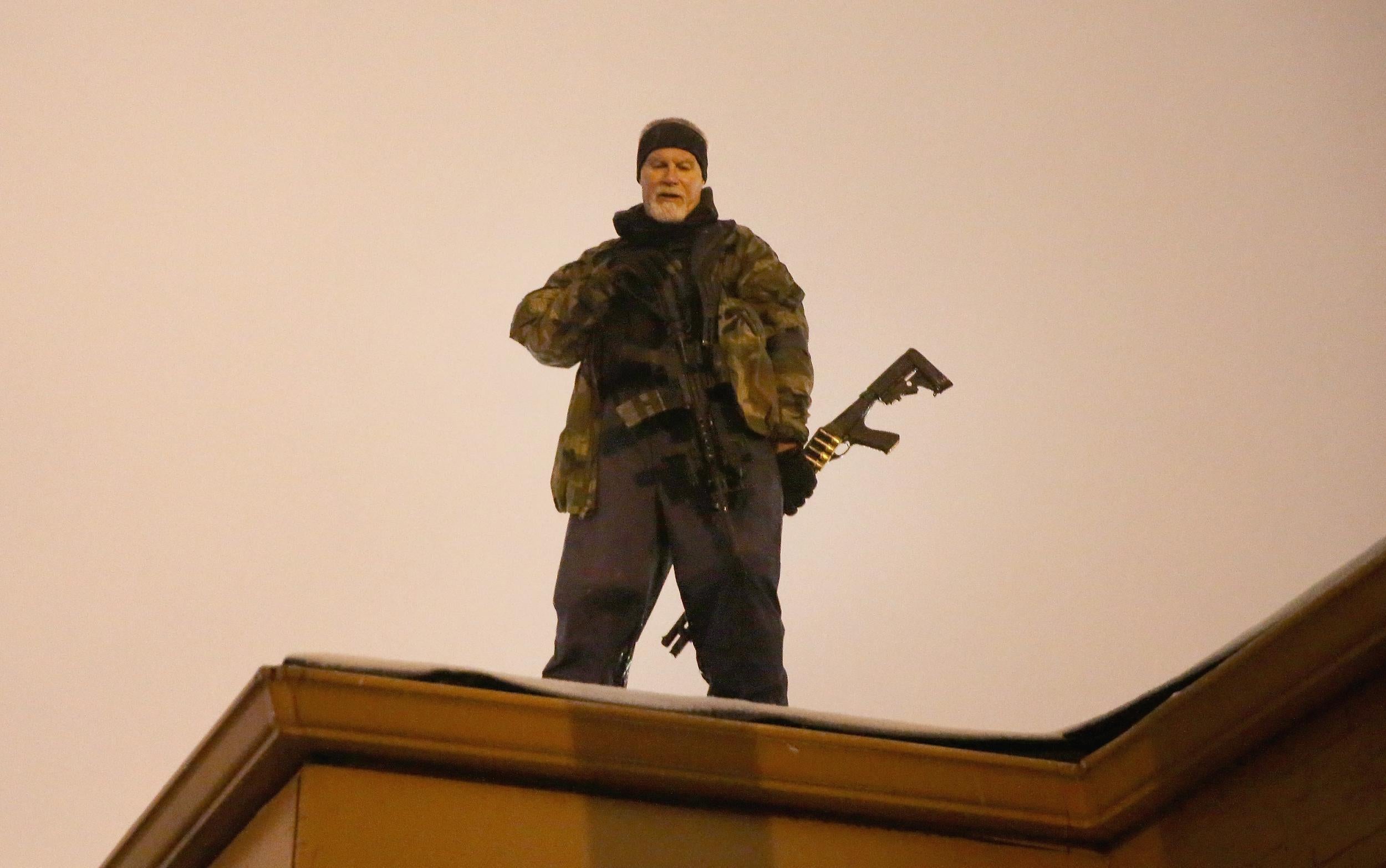 John Karriman. a volunteer from Oath Keepers, stands guard on the rooftop of a business in Ferguson, Missouri