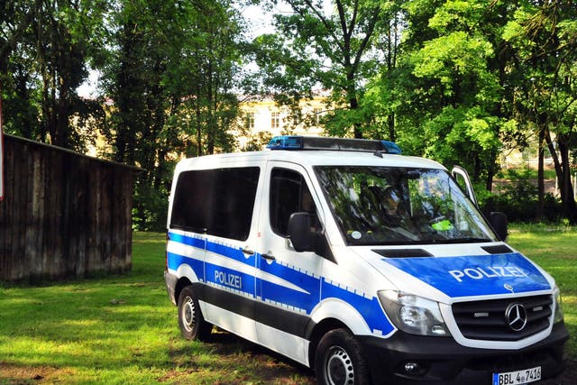 A police vehicle stands in front of a youth center in Gerswalde, Germany, where an asylum seeker was arrested after officers susptected he was planning a suicide attack in Berlin