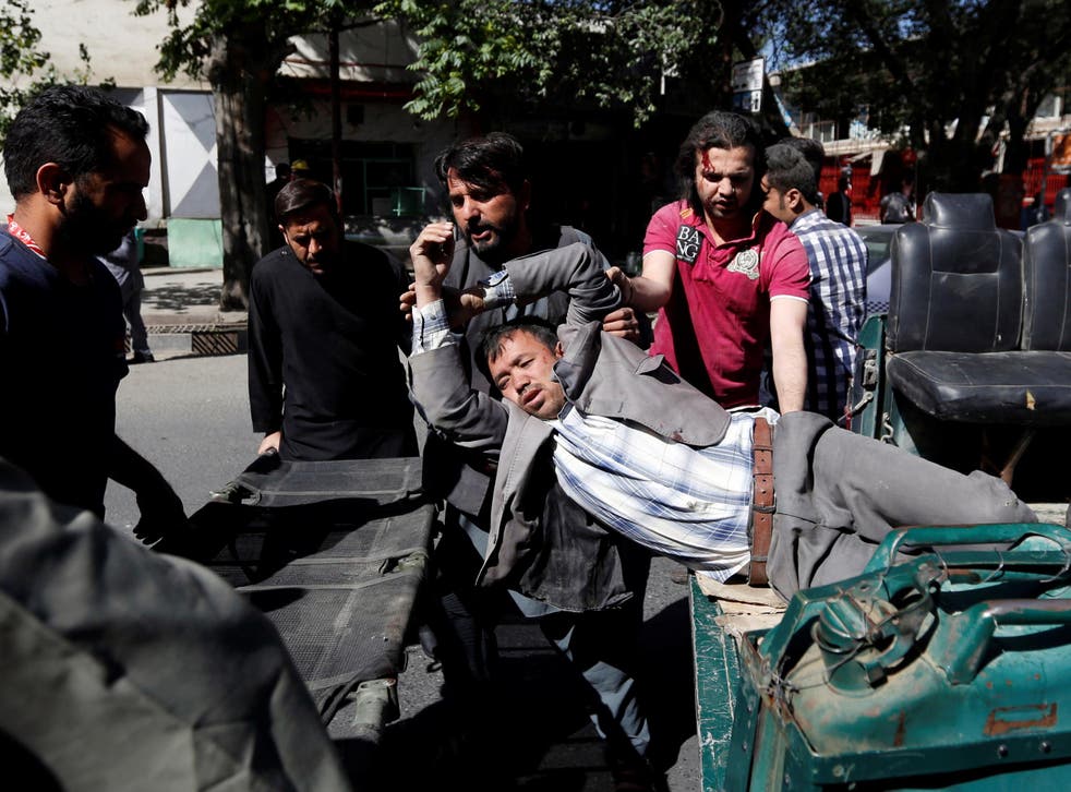 Men move an injured man to a hospital after a blast in Kabul