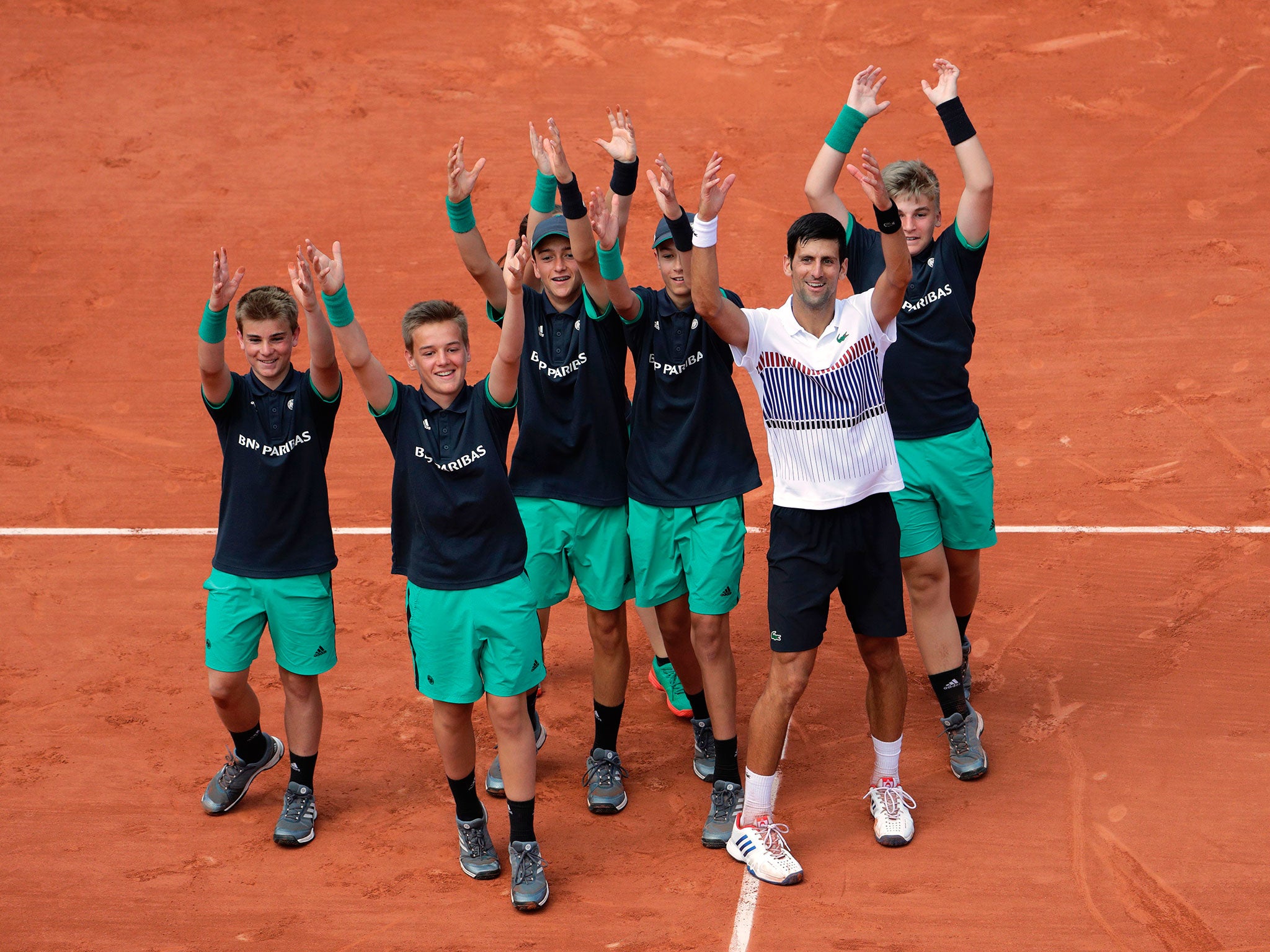 Novak Djokovic celebrates his victory with the Roland Garros ball boys