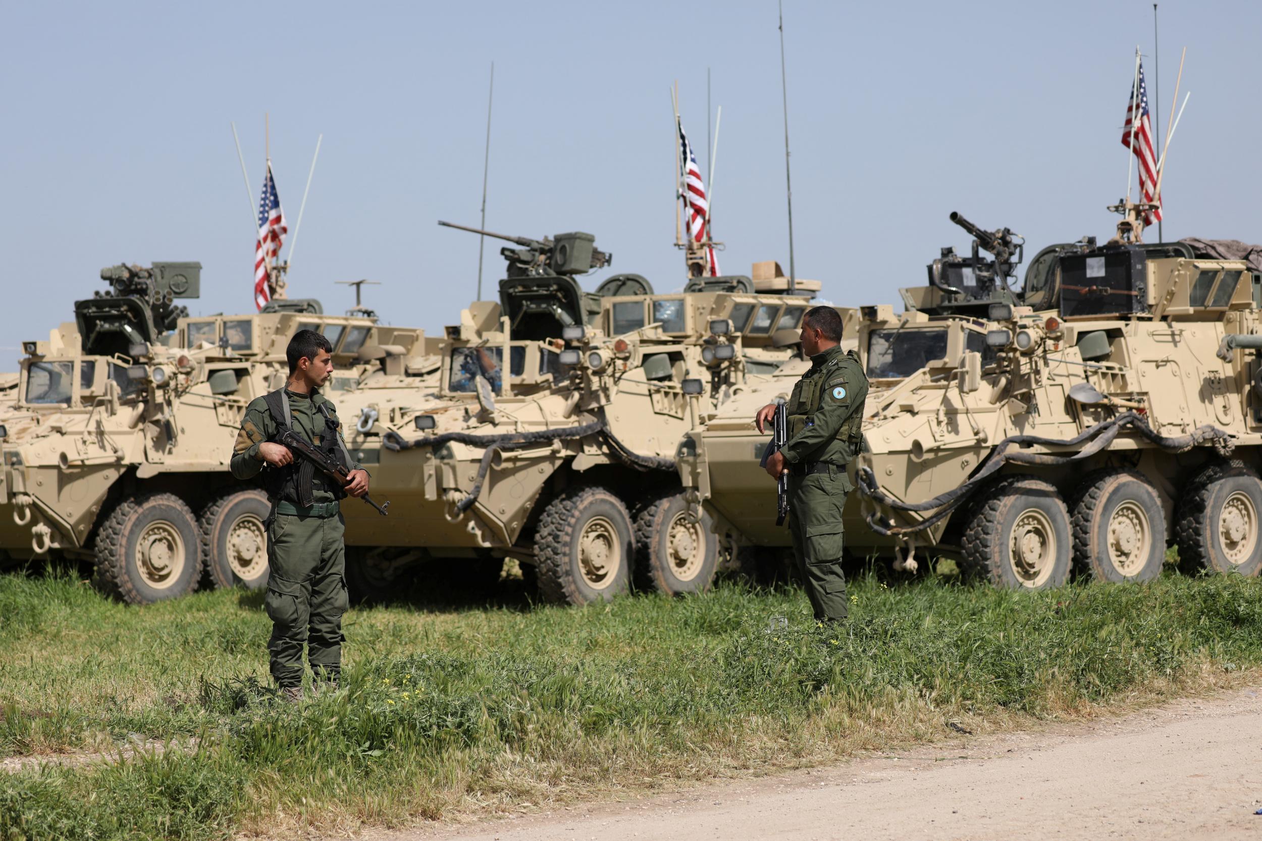 Kurdish YPG fighters stand near US military vehicles in the town of Darbasiya near the Turkish border, in Syria on 29 April 2017