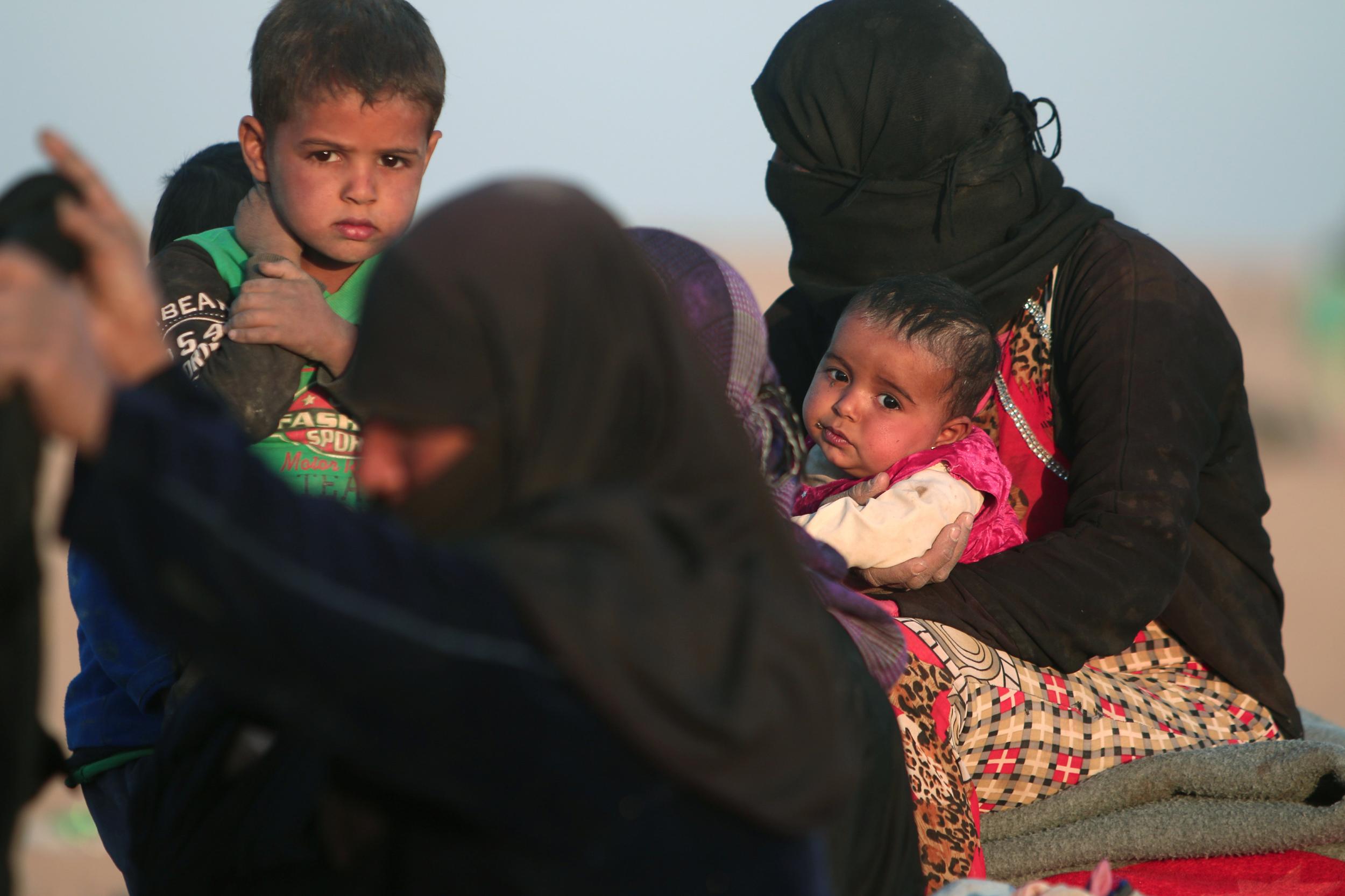 Women and children who fled violence in Mosul gather in Hasaka Governorate, just over the border in Syria, on 20 October 2016