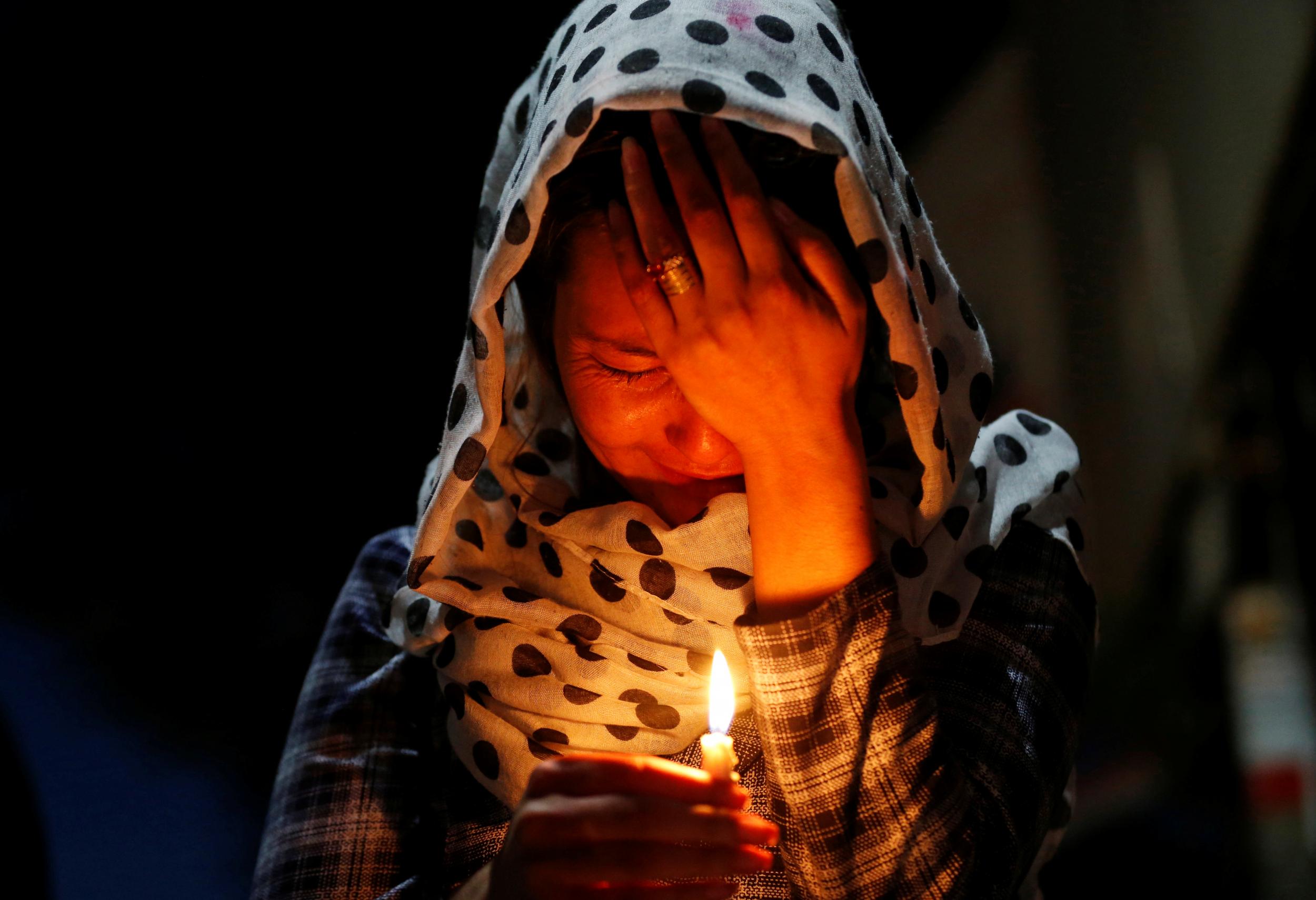 A woman cries as she holds a lit candle for the victims of Wednesday's blast in Kabul, Afghanistan on 1 June 2017
