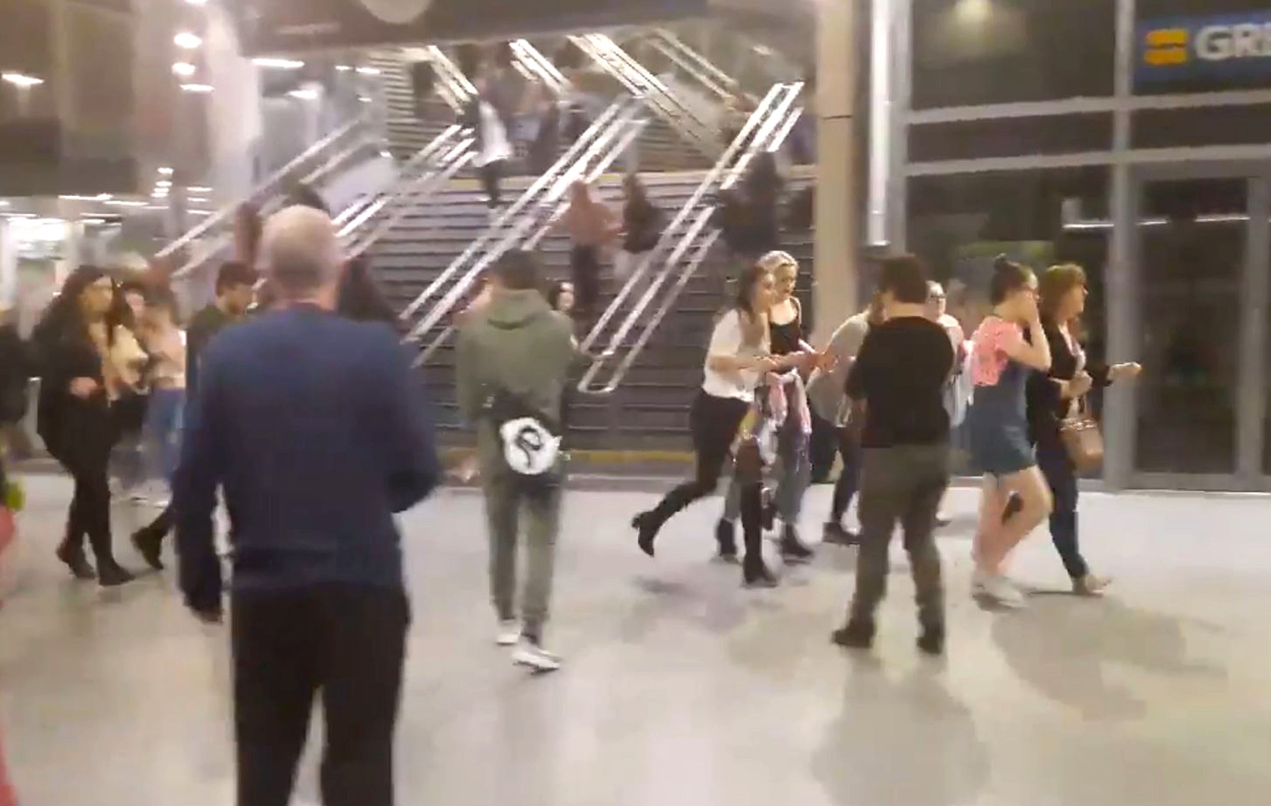 People run through Manchester Victoria station after the explosion on 22 May (PA)