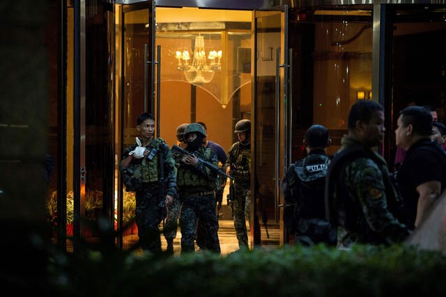 Philippines' police officers come out from the Resorts World Hotel in Manila on Friday following the attack