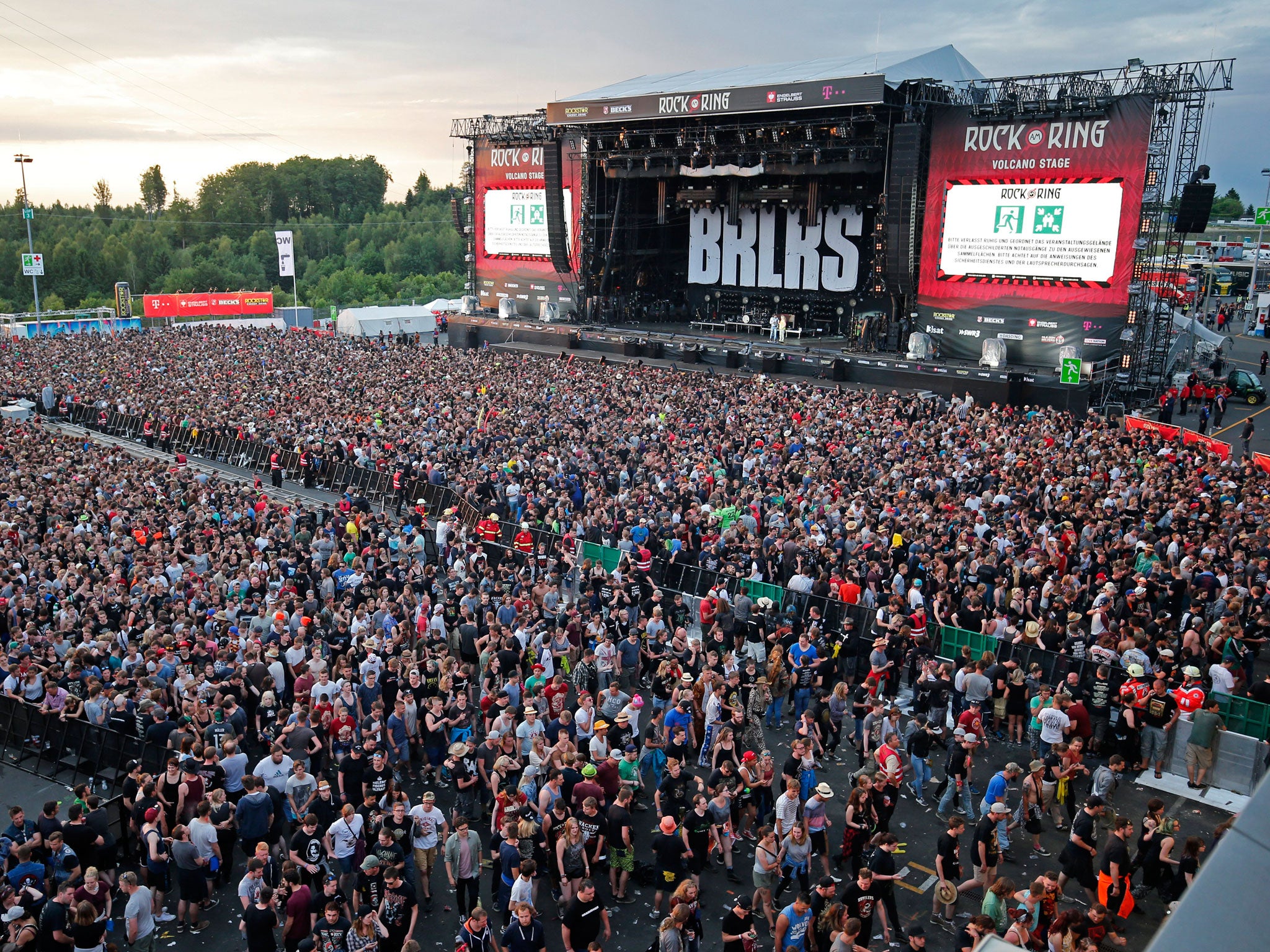 Festivalgoers leave the site of the 'Rock am Ring' festival at the Nuerburgring circuit after a terrorist threat warning