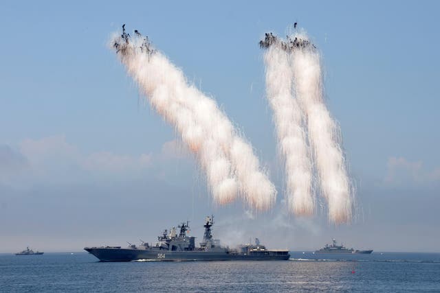 Russian warships sail past exploding anti-missile ordnance during a rehearsal for the Navy Day parade in 2016