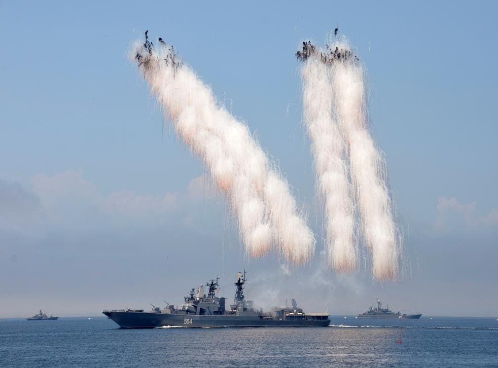 Russian warships sail past exploding anti-missile ordnance during a rehearsal for the Navy Day parade in 2016