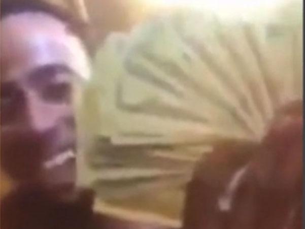 Breon Hollings waving money at the camera moments before SWAT team descends on his trailer (Facebook/ Breon Hollings)