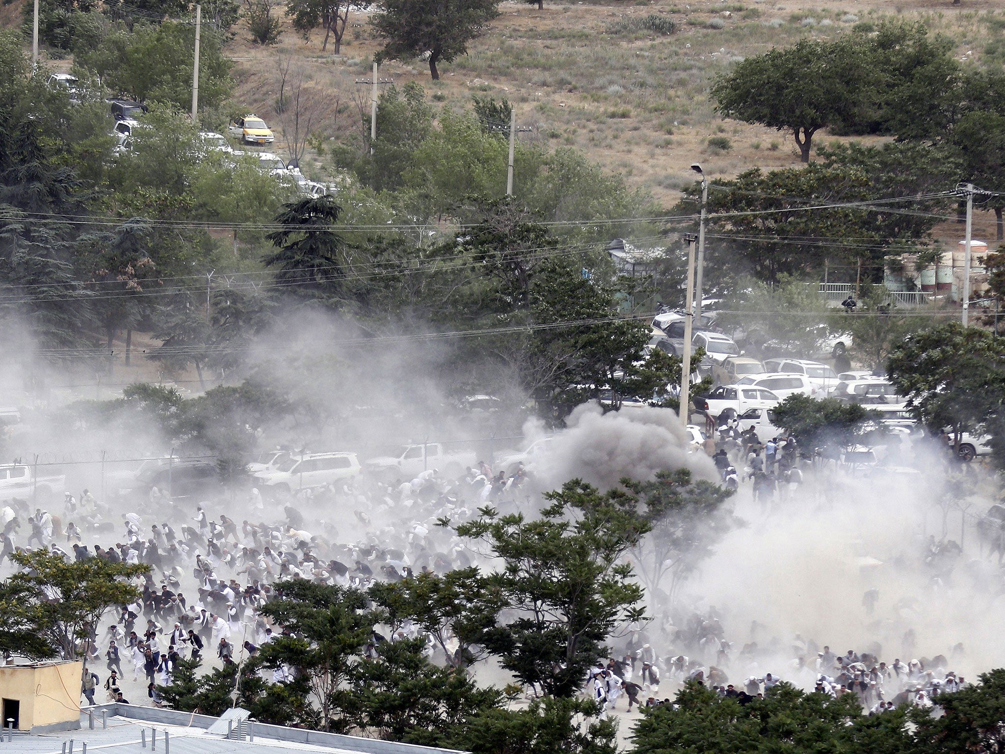 People run after an explosion during the funeral of a victim of the violent protests in Kabul, Afghanistan