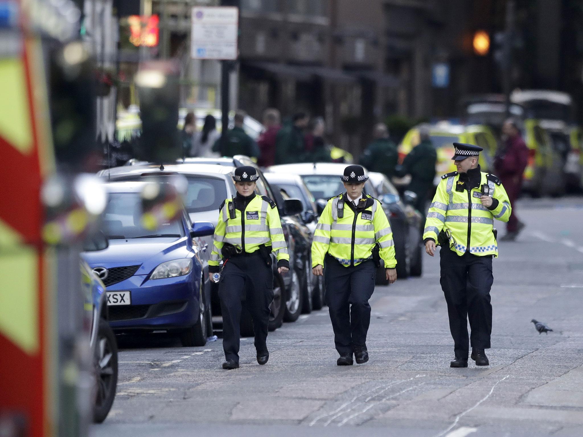 Police officers patrol a cordoned off area after an attack in the London Bridge