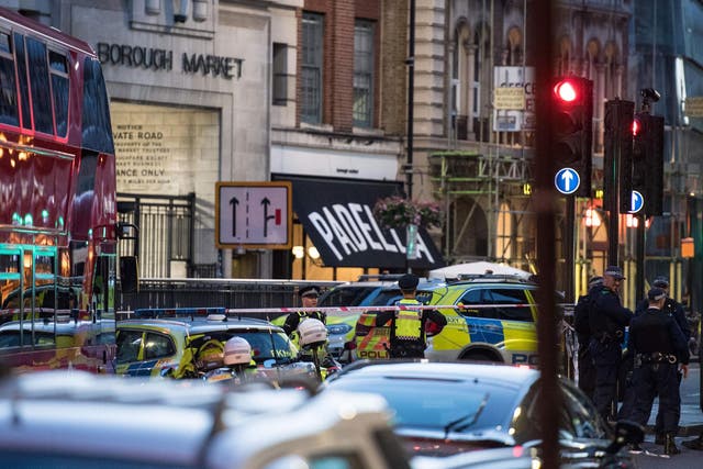 Police officers and emergency response vehicles are seen on the street outside Borough Market after terror attack