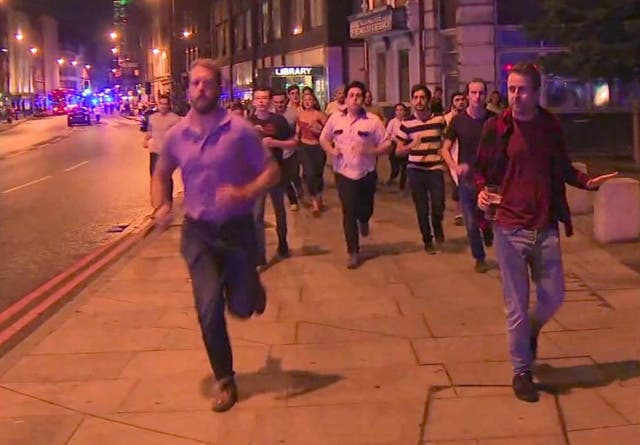 A man holds on to his beer as people flee from the scene of the attack