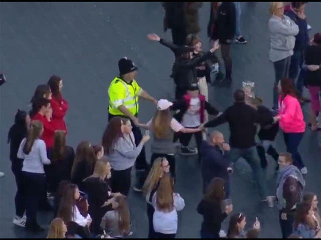 A policeman dances with children in the crowd at the Manchester One Love concert