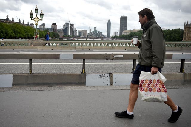 A pedestrian walks past barriers on Westminster Bridge