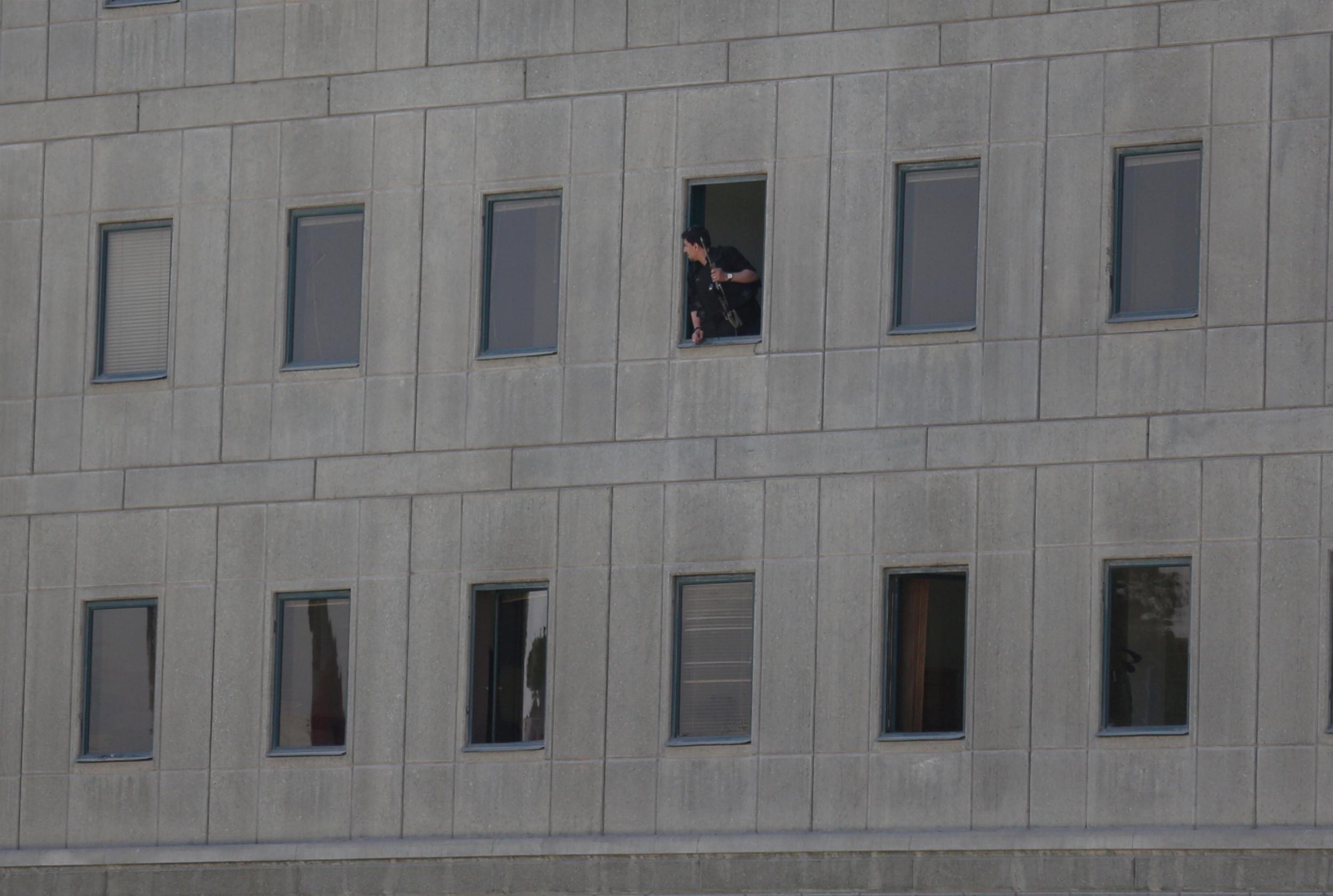 Lookout: police officer observes events in a wing of the parliament building in Tehran