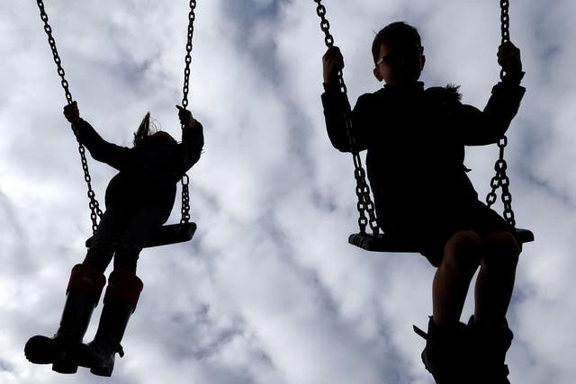 Stock image of children playing on the swings