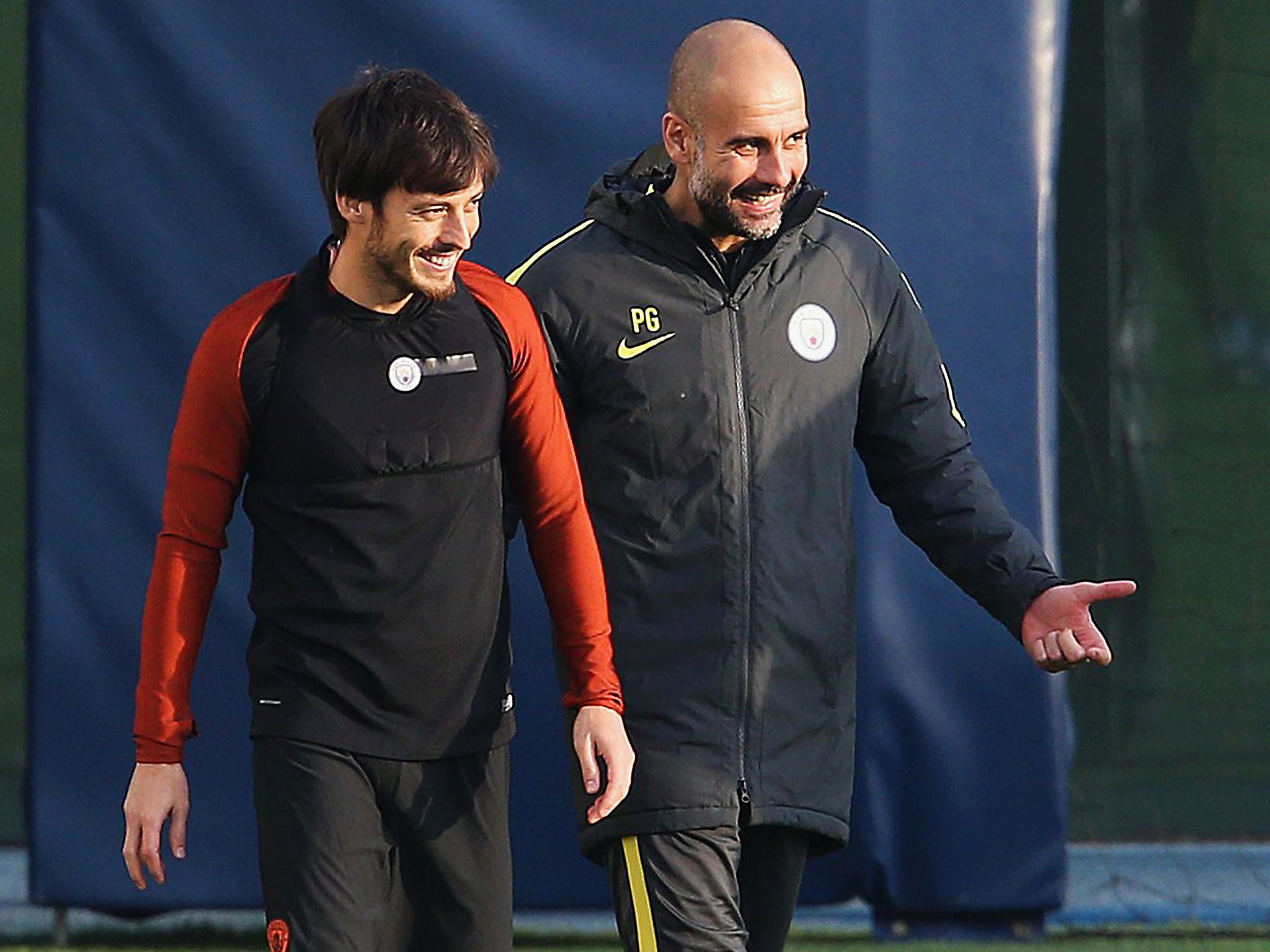 Manchester City manager Pep Guardiola talks with David Silva during a training session