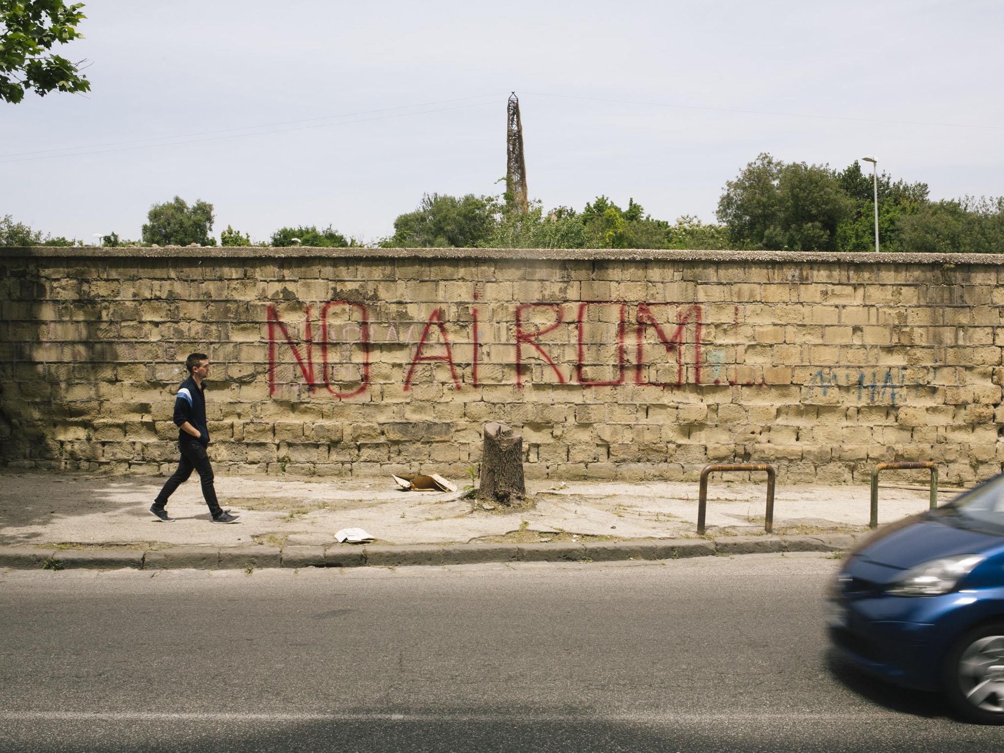 The perimeter wall surrounding the emergency housing is marred with anti-Roma graffiti