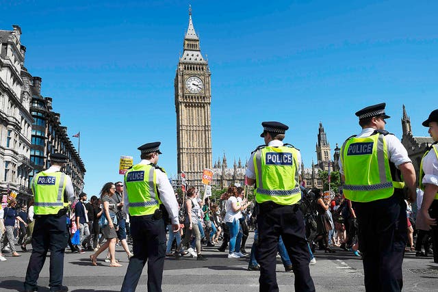 Police officers monitor a protest against the Conservatives deal with the DUP on June 10