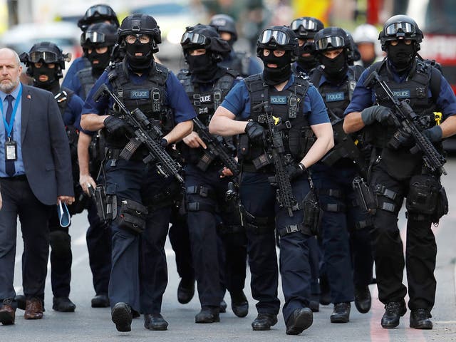 Armed police officers walk outside Borough Market after an attack left 6 people dead and dozens injured in London